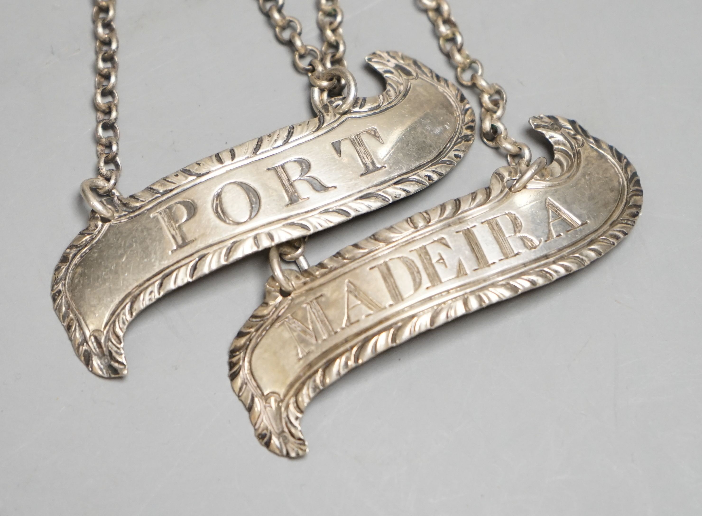 A pair of George III silver wine labels 'Port & Madeira', by Hester Bateman, no date letter, London, c.1775, 56mm.